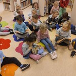 Dzieci siedzą na podłodze i oglądają książki