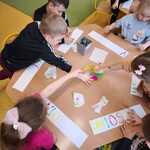 
Przedszkolaki przy stolikach wykonują kolorowy napis Wiosna.