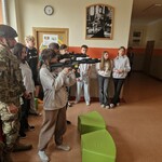 Ósmoklasiści podczas zajęć z uczniami szkoły mundurowej Feniks prezentacja uzbrojenia.jpg