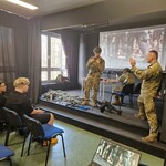 Uczniowie szkoły mundurowej Feniks podczas prezentacji w tle slajd z musztry.jpg