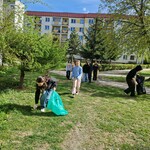 Uczennice z zaangażowaniem sprzątają tereny zielone.jpg
