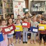 Zdjęcie grupowe przedszkolaków z grupy Pszczółki z panią bibliotekarką 

