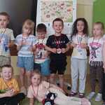 Dzieci z medalami i kotkiem Bofkiem pozują do zdjęcia 