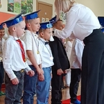 Nauczycielka wręcza medale dzieciom
