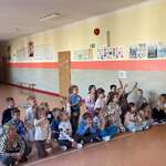 Dzieci siedzą na korytarzu szkolnym_ zgłaszają się do odpowiedzi.jpg