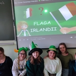 klasa 4b przy tablicy interaktywnej w zielonych nakryciach głowy.