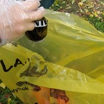 uczennica w plastikowej rękawiczce wrzuca śmiecie do żółtego worka.