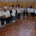 uczniowie ustawieni w dwuszereg na sali gimnastycznej na apelu