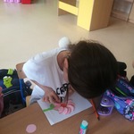 dziewczynka wykonuje kwiatka techniką origami koła