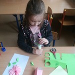 dziewczynka wykonuje kwiatka techniką origami