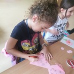 dziewczynka rysuje mazakiem na piesku wykonanym techniką origami 