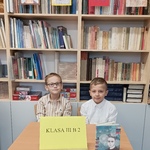 drużyna 2 z klasy 3b -dwóch uczniów, siedzących przy stoliku na tle regałów z książkami