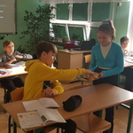 uczennica podaje na tacy ciasteczko uczniowi