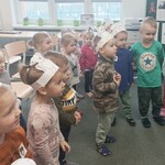 dzieci z opaskami z misiami na głowie, śpiewają i tańczą