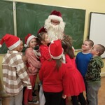 dzieci z klasy 1b tulą się do Mikołaja