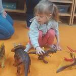 dziewczynka bawi się dinozaurami