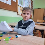 uczeń wyjmuje z koperty różnokolorowe figury geometryczne