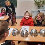 dziecko z mamą przy stoliku na którym ustawiono 5 odwróconych misek 