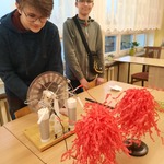 dwaj uczniowie wykonują doświadczenie fizyczne