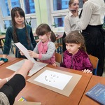 dwie dziewczynki pochylone nad kartkami z bloku rysują kleksy