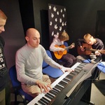 nauczyciel i uczniowie grają na instrumentach