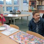 dzieci  z rodzicami oglądają książki w czytelni