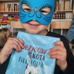 chłopiec w masce kota trzyma książkę 
