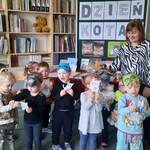 dzieci z papierowymi kotkami i panią bibliotekarką na tle dekoracji