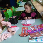 dwie dziewczynki kolorują domki