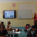 Strażnik miejski i ratownik medyczny w klasie na zajęciach z młodzieżą. Na ekranie napis Ochrona osobista