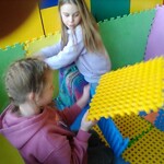 dwie dziewczynki bawią się dużymi klockami