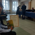 uczeń z dyplomem i książką za udział w konkursie