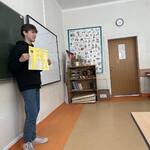 uczeń na tle tablicy prezentuje swojego lapbooka