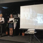Na scenie uczeń i uczennica zapraszają do obejrzenia prezentacji o naszej szkole, na dużym ekranie wyświetlana prezentacja