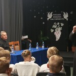Arcybiskup przemawia do zgromadzonych w sali teatralnej