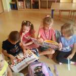 dzieci siedzą na podłodze i czytają książki