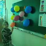 dziewczynka przed tablicą z balonami