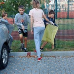uczniowie zbierają śmieci przed szkołą
