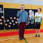 Dwie nauczycielki trzymają medale, nauczyciel trzyma mikrofon