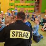 Dzieci słuchają opowieści o zawodzie strażak.