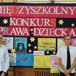 Nagrodzeni uczniowie naszej szkoły na tle tablicy z plakatami nagrodzonymi w konkursie