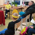 Dzieci z rodzicami oglądają teatrzyk kamishibai