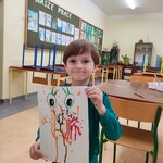 Chłopak prezentuje swoją pracę plastyczną