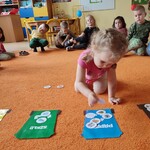 Dziewczynka na dywanie dopasowuje odpowiedni element