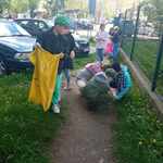 dzieci zbierają śmiecie i wrzucają do worków