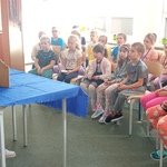 Uczniowie klas pierwszych w czytelni oglądają teatrzyk kamishibai