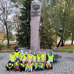 Zdjęcie grupowe dzieci z grupy Wiewiórki przed pomnikiem 