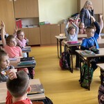 Uczniowie zgłaszają się do odpowiedzi na pytania zadawane przez policjantkę