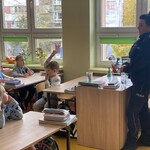 Policjantka pyta uczniów o zasady bezpiecznego poruszania się po drodze