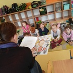 Dzieci uważnie słuchają czytanej książki
